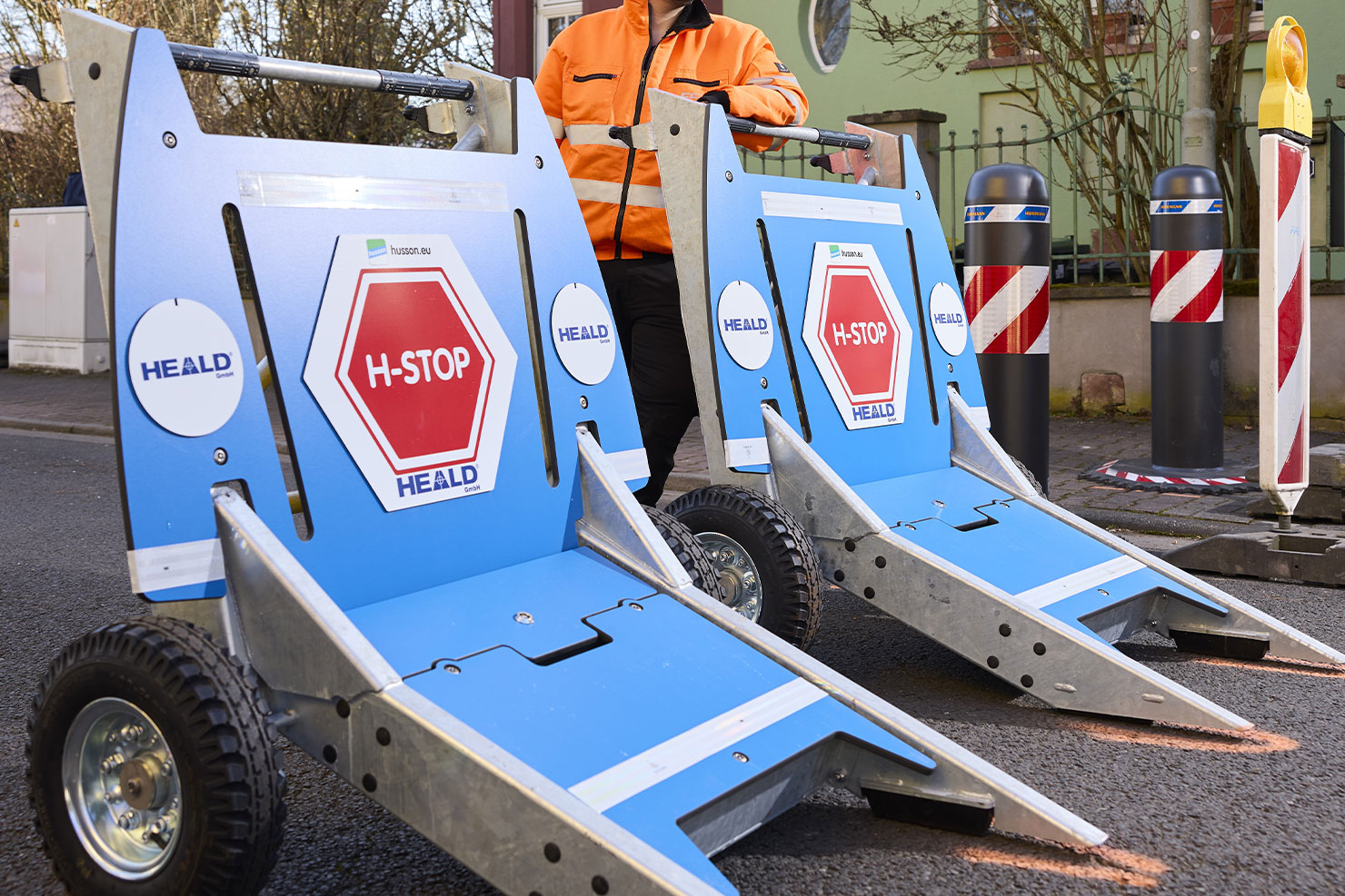 Ein FFR-Mitarbeiter steht hinter zwei mobilen Fahrzeugsperren der Art H-Stop.