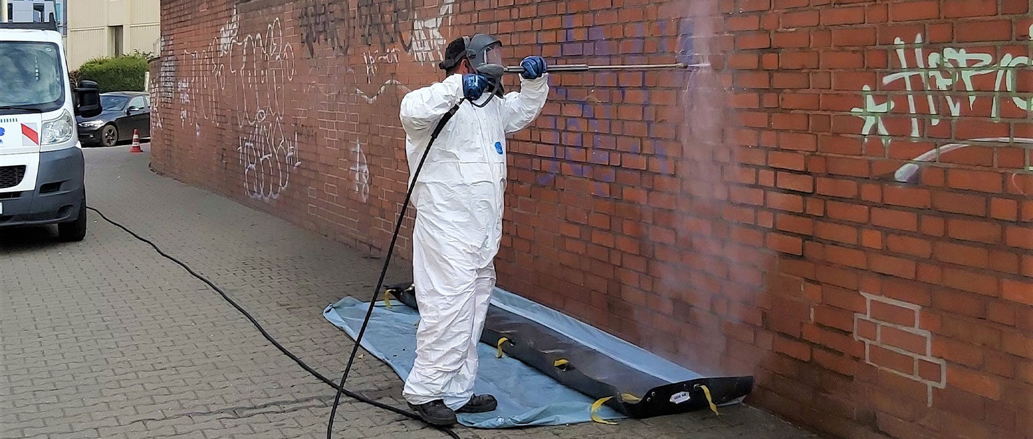FFR-Mitarbeiter reinigt eine Wand mit Graffiti