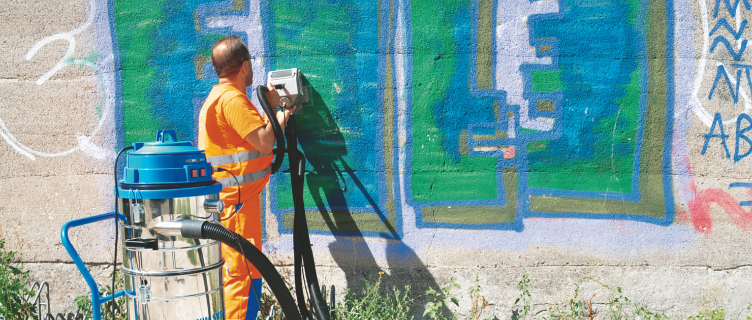 FFR-Mitarbeiter entfernt Graffiti an Hauswand mit Reinigungsgerät