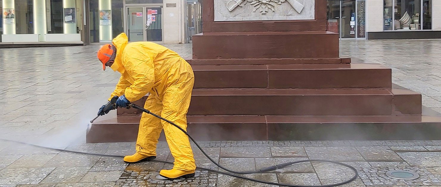 FFR-Mitarbeiter reinigt die Stufen eines Denkmals