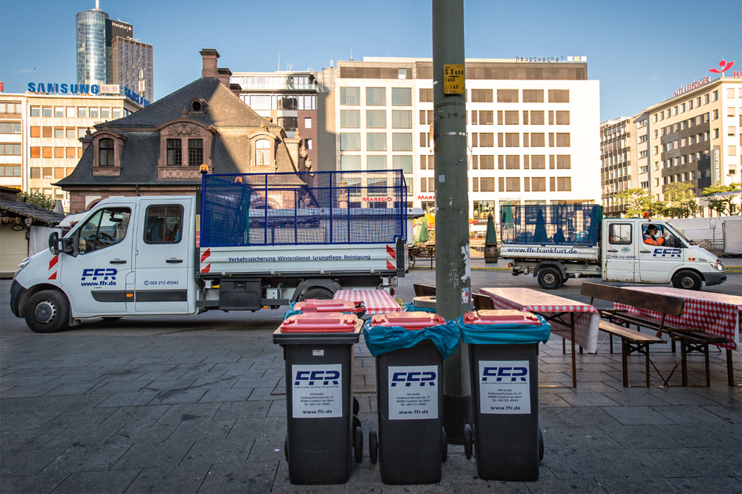 Abfalltonnen und Transportfahrzeuge auf einem Veranstaltungsplatz
