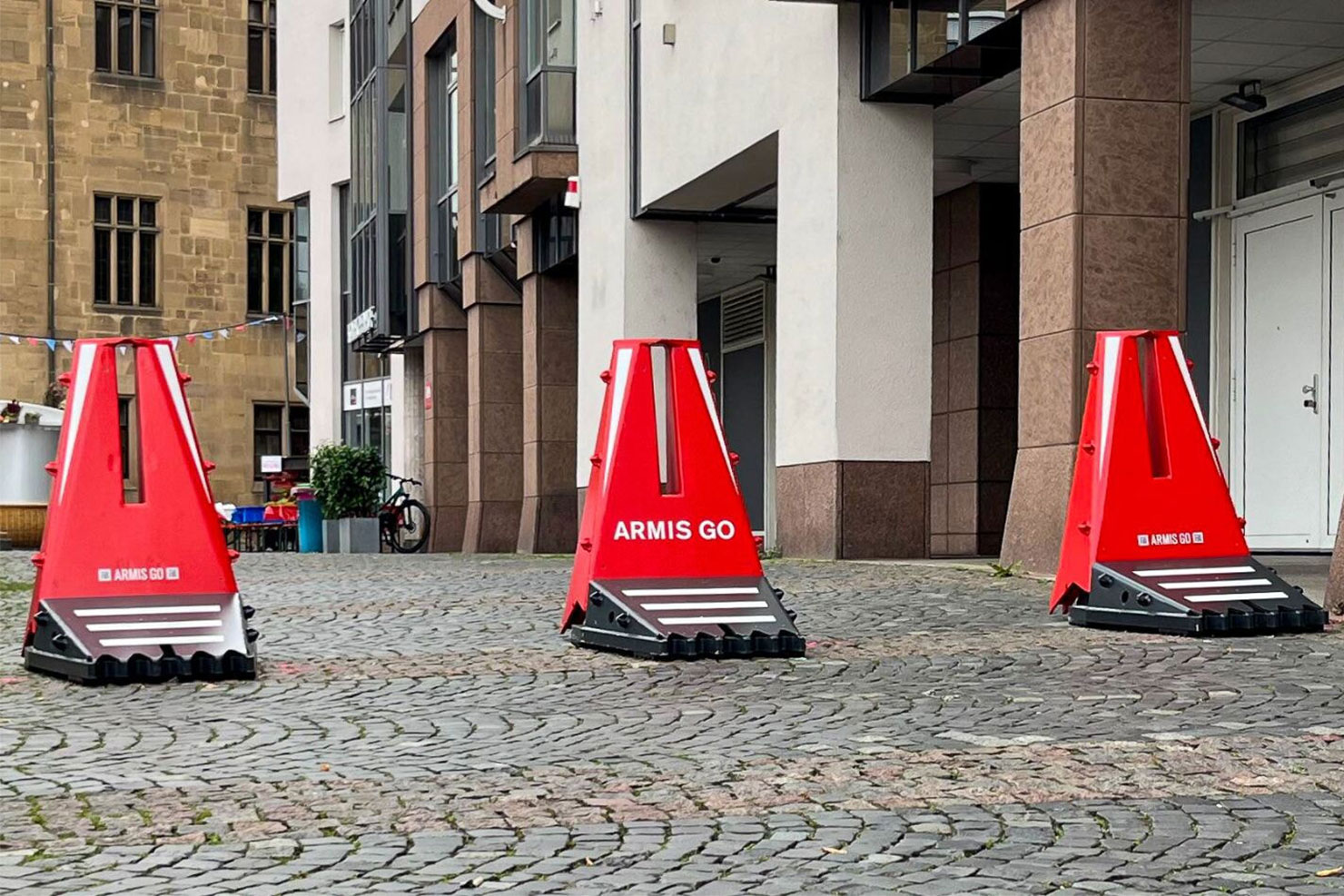 Drei mobile Fahrzeugsperren der Art ARMIS GO stehen in einer Fußgängerzone.