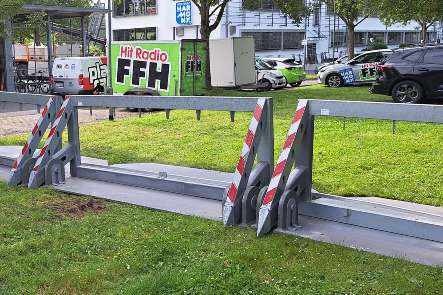 Zwei mobile Fahrzeugsperren der Art SafetyClaw stehen auf einem Rasen.