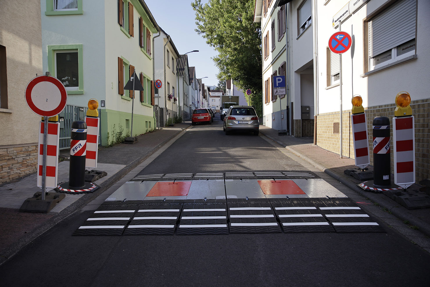 Zwei zugeklappte mobile Fahrzeugsperren eröffnen eine Straße für den Verkehr.