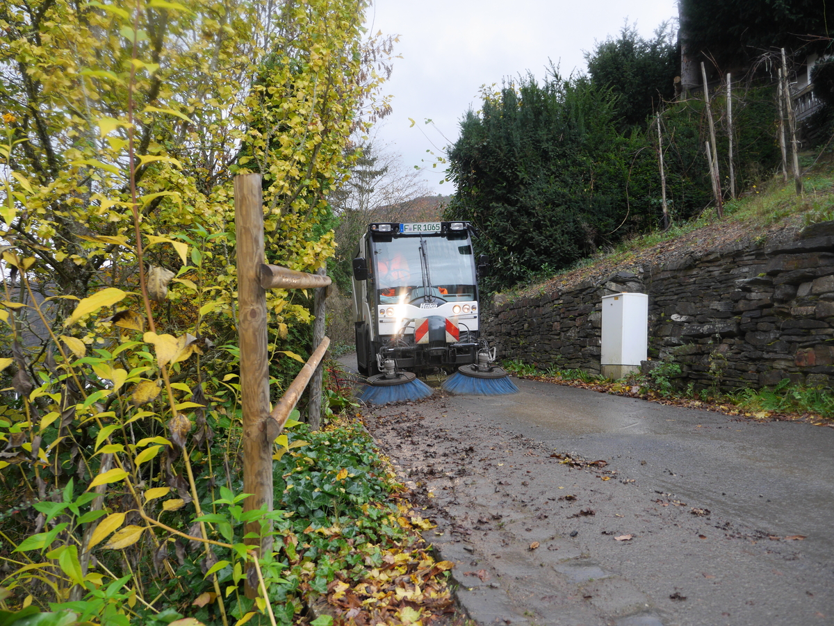 Kleinkehrmaschine reinigt eine schmale Straße
