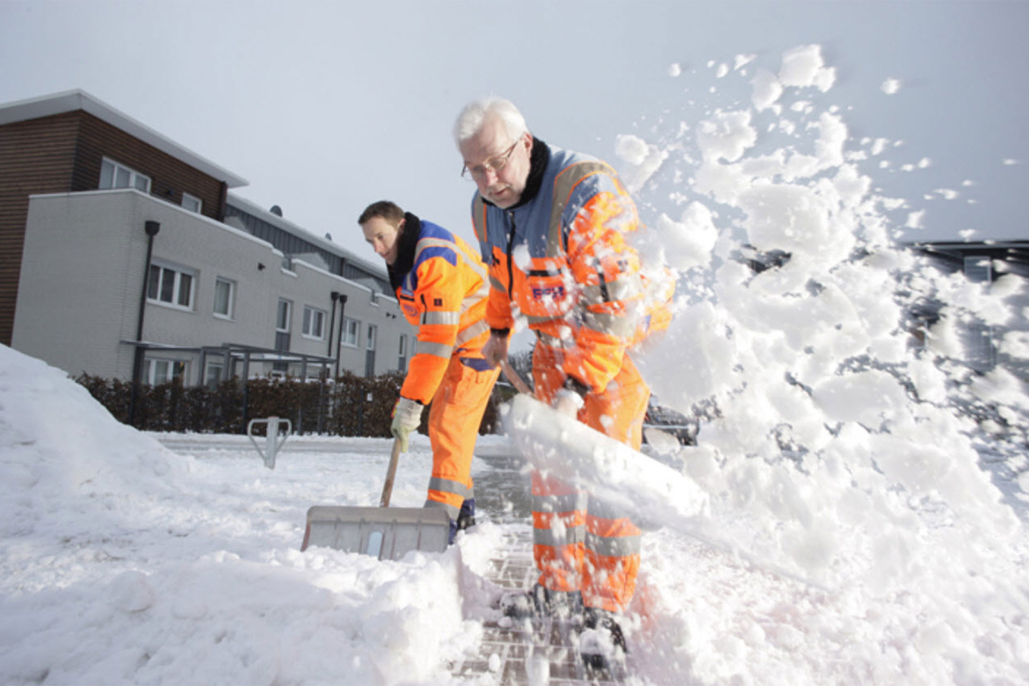 Zwei FFR-Mitarbeiter schippen Schnee