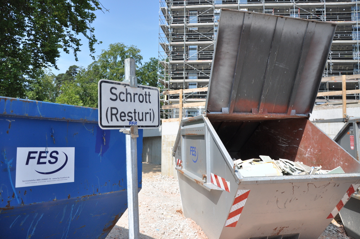 Container an Baustelle, daneben Schild: Schrott (Resturi)