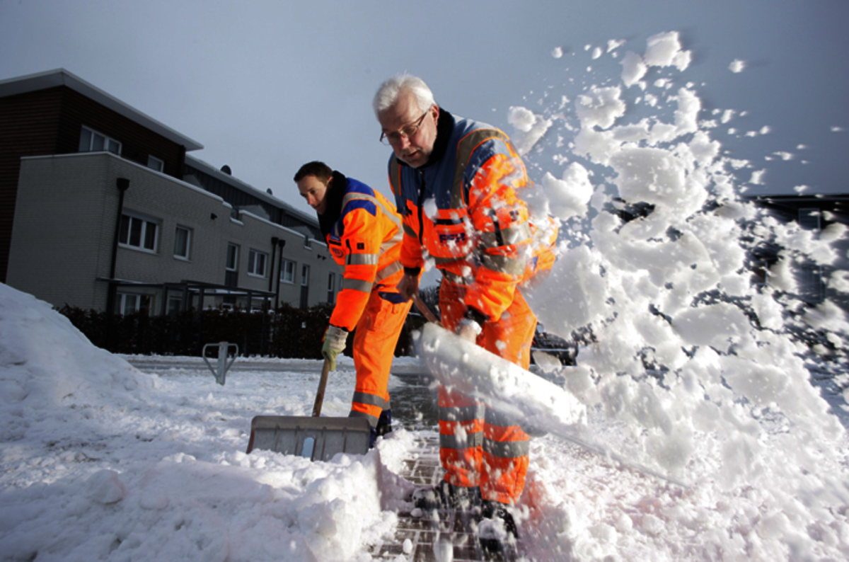 Mitarbeiter schippen Schnee