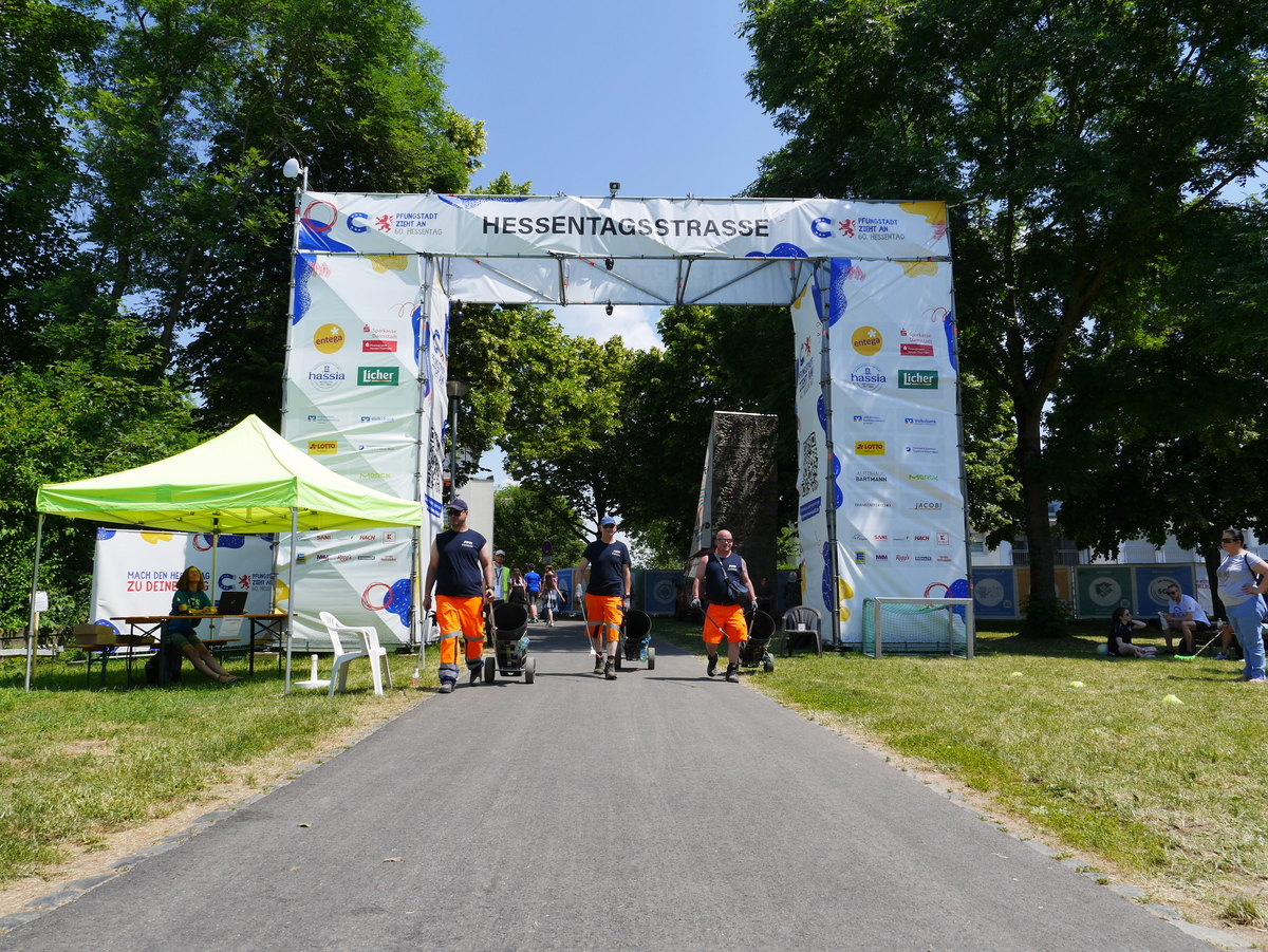 Drei Mitarbeiter mit mobilen Mülltonnen bei der Veranstaltung Hessentag