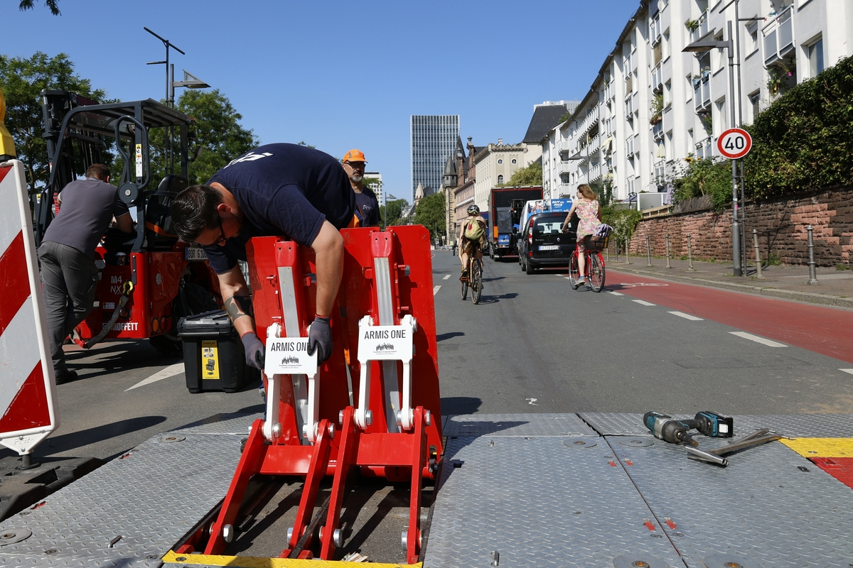 Mitarbeiter baut ausklappbare mobile Fahrzeugsperren auf