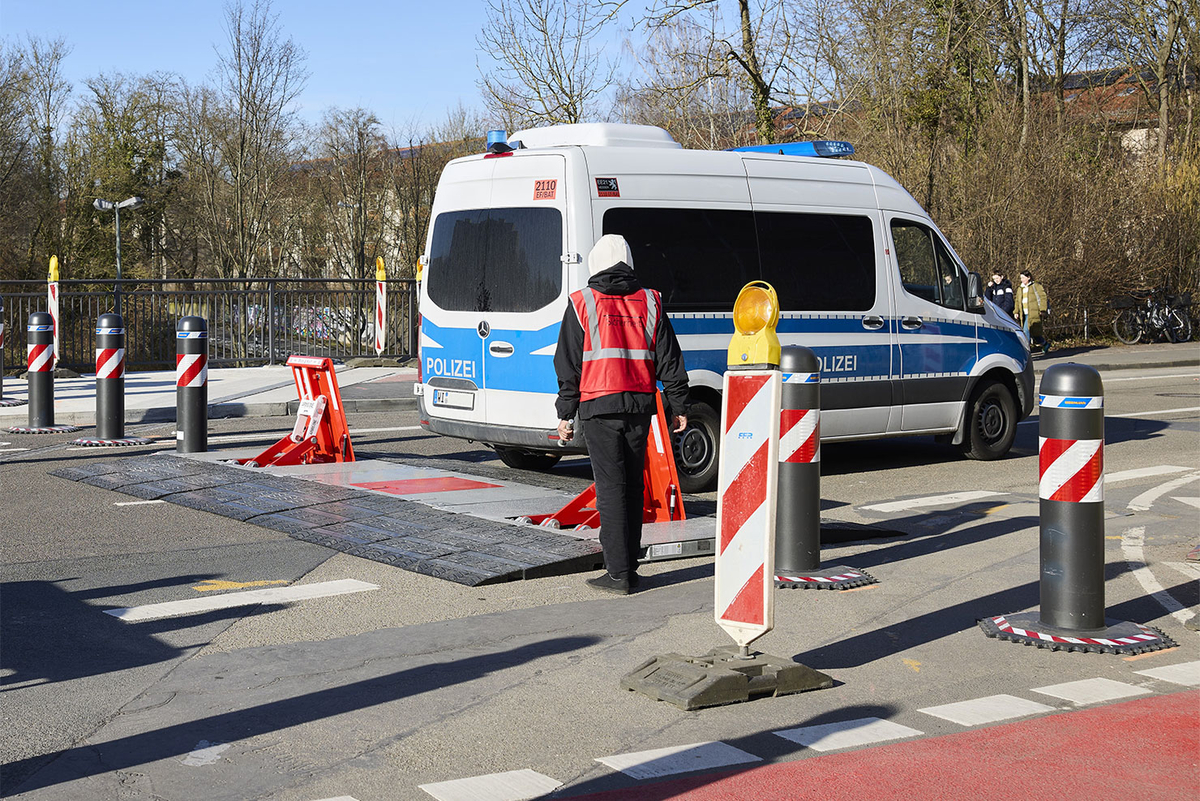 Ein Polizeiwagen passiert eine zugeklappte Fahrzeugsperren.